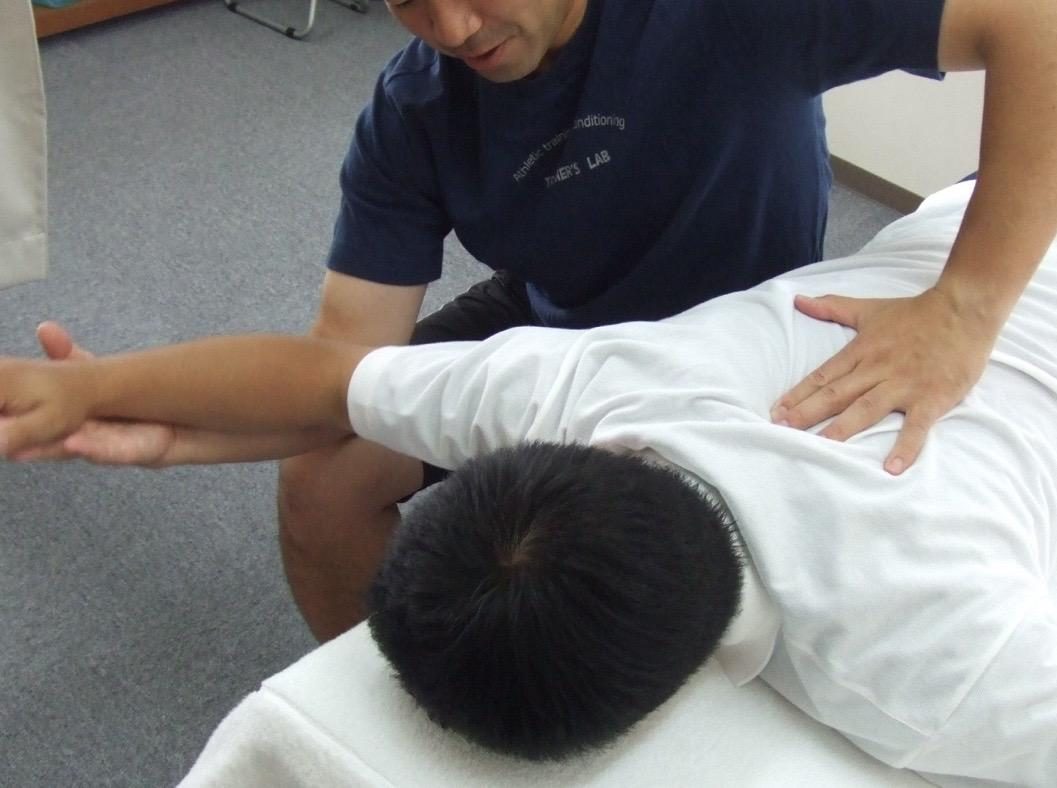 背中と肩甲骨に手技でアプローチする施術の様子